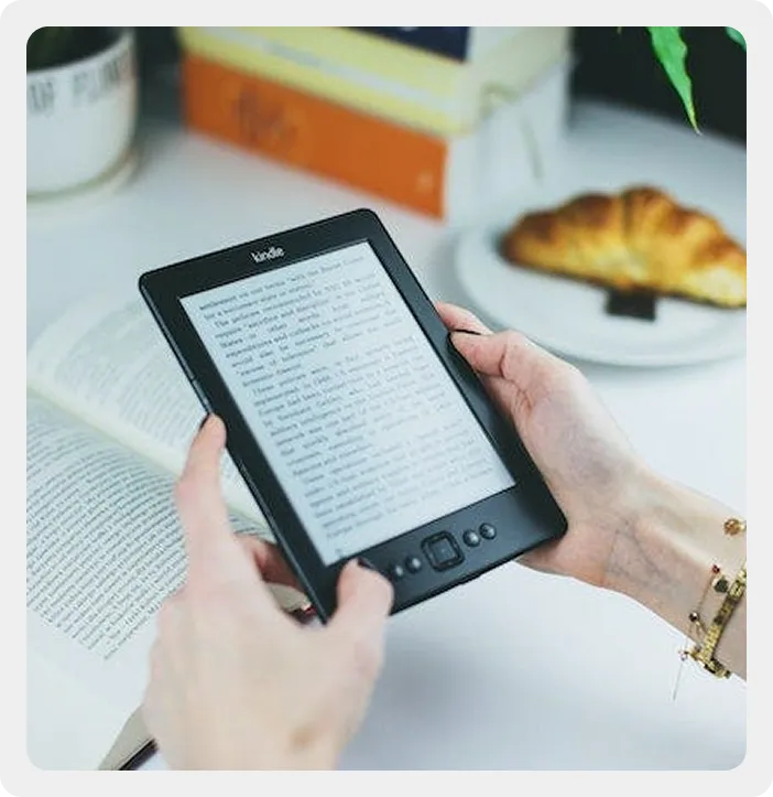 Reader holding an e-reader displaying a published eBook